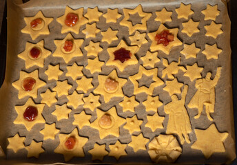 Handmade Christmas Cookies - stars and Super hero shapes, on a sheet of baking paper