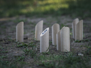 Molkky : Finnish family outdoor throwing game. Numbered wooden pieces or skittles in the grass.