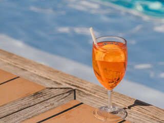 Beautiful glass with a refresh cocktail standing by the pool. View from above, close-up. Vacation and travel concept. Moments of celebration