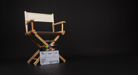 White director chair with clapper board on black background - obrazy, fototapety, plakaty