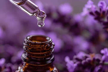 Tuinposter Drop of essential oil falling from a dropper into a glass bottle, with fresh lavender flowers in the background © Madeleine Steinbach