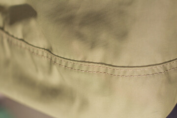 protective work clothes in beige and brown colors. Factory stitches on thick fabric. Close-up texture