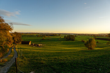 Fototapeta premium Landschaftsbild in der Abendsonne, mit Blick nach Süden, im Hintergrund die Alpen.