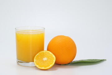 glass of orange juice and orange on white background