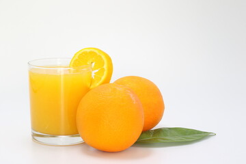 glass of orange juice and orange on white background
