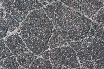 Background, texture, top view of wet asphalt with cracks on the road. Photography, abstraction, pattern on the ground.
