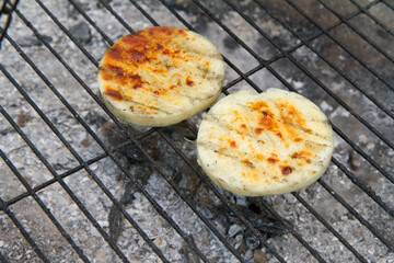 Cheese being grilled in a garden - 704377344