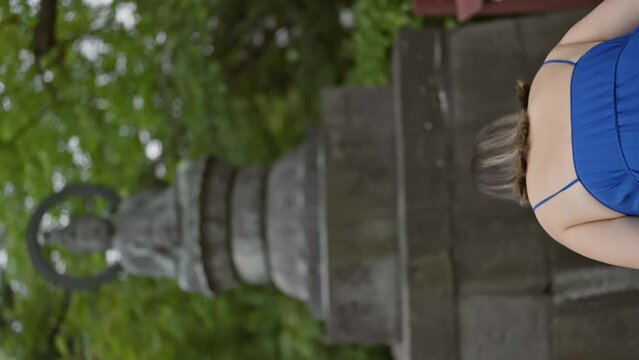 Beautiful hispanic woman in glasses finds peace praying to buda at tokyo's ancient senso-ji temple