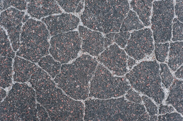 Background, texture, top view of wet asphalt with cracks on the road.