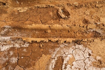 Trace of a car wheel on on the mud, soil land. Driving on desert sand after rain. Car tread...