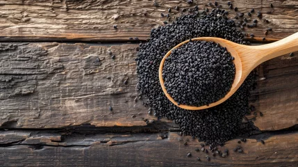 Poster Heap of black Sesame seeds in wooden spoon on old wooden background.Top view.  © buraratn