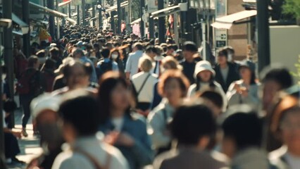 Unfocused blurry crowd of people walking in the street. Slow motion.