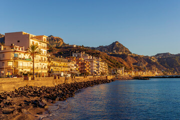 morning sunrise landscape on a city emnarkment with beach and sea coast and beautiful mediterranean street with buildings