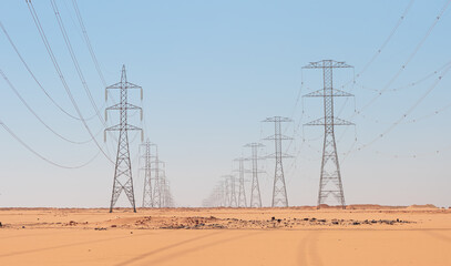 Power line transmission towers surround the Sahara in the desert in Egypt