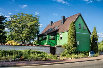 Fototapeta na wymiar gommern, germany - idyllisches grünes haus mit mauer
