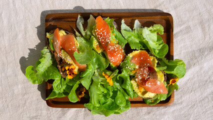 bruschetta with avocado and smoked salmon on a wooden plate