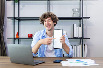Caucasian man is working at his home office while presenting the new project using digital tablet...