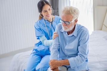 Hospice nurse is using stethoscope on Caucasian man in bed for diagnosing lung cancer and heart rate at pension retirement center for home care rehabilitation and post treatment recovery process