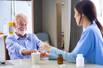 Senior caucasian man got medical service visit from caregiver nurse at home while explaining on...