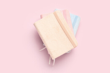 Stack of notebooks on pink background