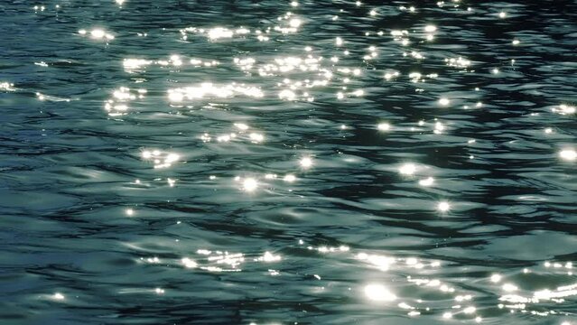 Slow motion of golden glittering sea surface, abstract background.