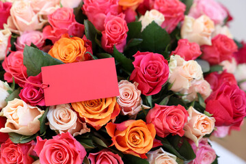 Bouquet of beautiful roses with blank card, closeup