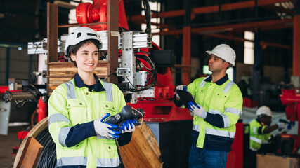 Fototapeta premium Portrait of Engineers inspecting and check up machine of the automated arms machine welding robots at factory. Technician controlling the automated arms machine welding robots.