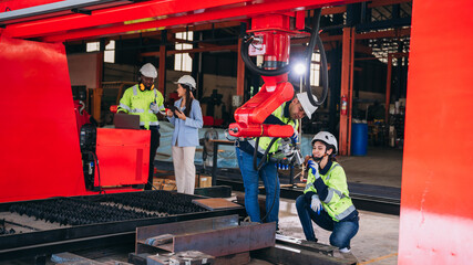 Obraz premium Engineers inspecting and check up machine of the automated arms machine welding robots at factory. Technician controlling the automated arms machine welding robots..