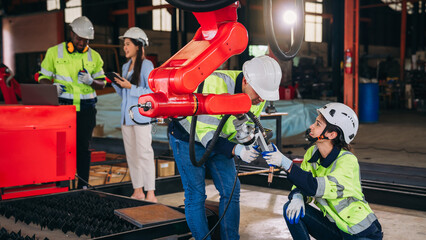 Engineers inspecting and check up machine of the automated arms machine welding robots at factory....