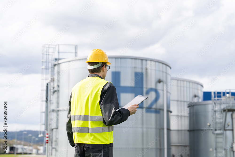 Poster Engineer with tablet computer on a background of Hydrogen factory