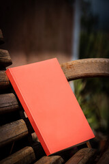 Outdoor Reflections: Orange Notebook on a Wooden Bench
