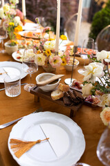Wedding table for guests, decorated with candles, are served with cutlery and crockery and covered with yellow tablecloth