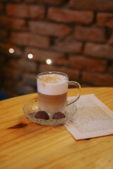 beautiful cappuccino in a glass mug inside a cozy café