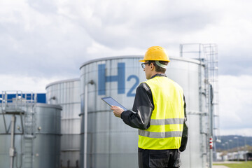 Engineer with tablet computer on a background of Hydrogen factory