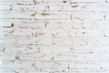 The texture of the old brick wall painted white with peeling paint. Cream and white brick wall texture background. Brickwork and stonework flooring interior rock old pattern design