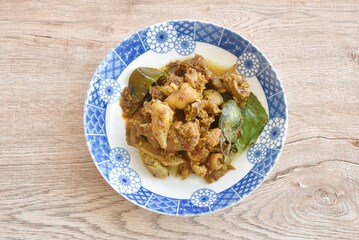 spicy fried chop chicken bone with basil in chili curry sauce on plate