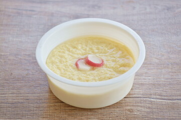 steamed egg with water topping slice crab stick in white plastic cup on table