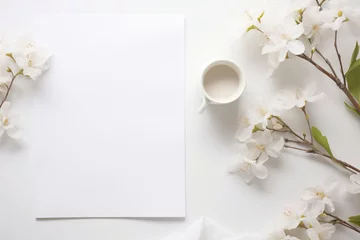 Fotobehang background for a concept of tender spring. a top view on an empty blank piece of paper for a letter or journalling or a postcard on white surface, cup of cappuccino and cherry apple tree blossom © Romana