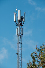 Closeup of a modern communications tower with bright blue sky in the background. - obrazy, fototapety, plakaty