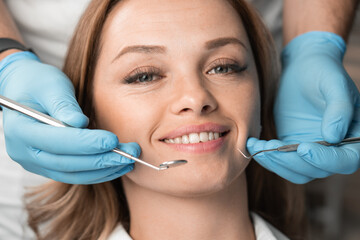 The dentist, holding the instruments, confidently and carefully treats the patient, providing a...