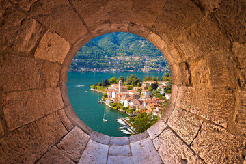 Idyllic town of Torno on Como lake view through stone window
