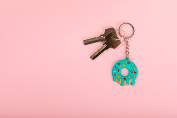 Donut shaped keychain with key ring on a colored background. Concepts for real estate and moving home or renting property. Buying a property. Mock-up keychain.Copy space. - obrazy, fototapety, plakaty