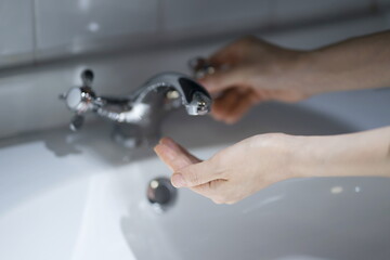 Close Up of Woman Opening Faucet