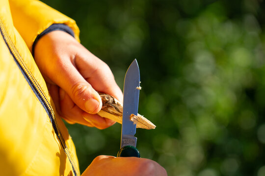 Boy peeling a stick with a razor