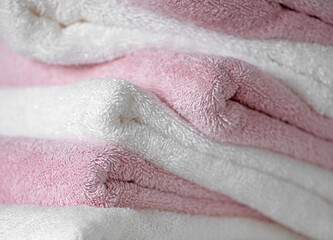 Pink and white terry and soft towels folded close-up