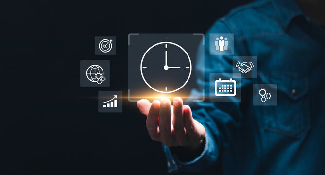 Time management concept. Businessman holding virtual time management icons for business to work planning for increases efficiency and reduced work time. Business project planning.