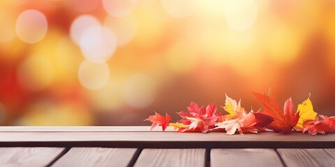 Blurred Autumn background with red-yellow leaves and wooden table.