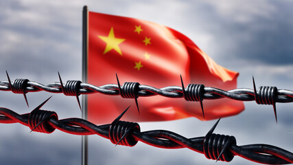 Chinese flag behind barbed wire. Metaphor restrictions against China. Flag of China flutters in...