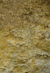 Texture of a wall of solid yellow and brown sand in a sandy quarry