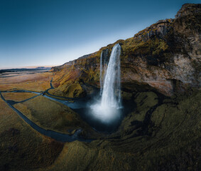 Aerial shot of Seljalandsfoss is located in the South Region on Iceland. Visitors can walk behind. Seljalandsfoss waterfall with a great sunset on popular tourist destination. Part of the golden